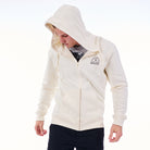Person wearing a cream hoodie with a brand logo on a white background