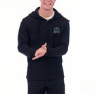 Person wearing a black hoodie with a logo on a white background